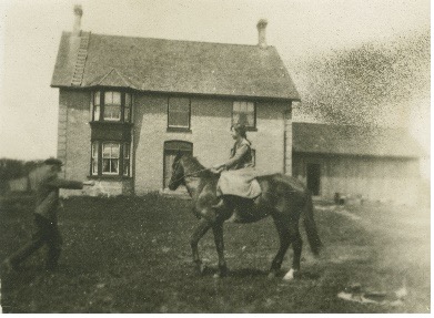 Photo of Elizabeth Oliver "Olive" Burgess on a horse with her father