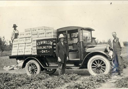 Three men with truck loaded with crates