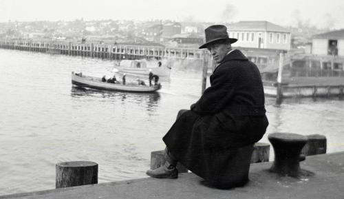 Franklin McMillan sitting on pier looking at boat in harbour